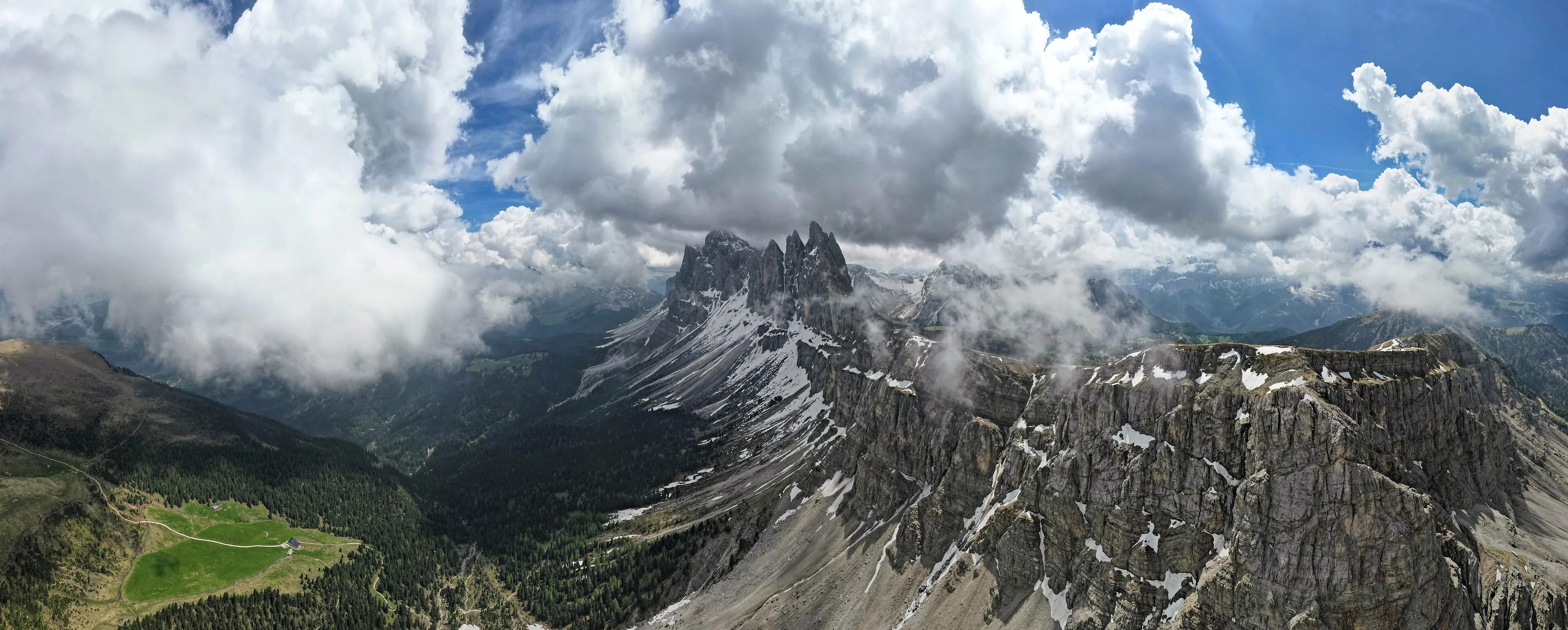 Jagged Odle/Geisler peaks of the Dolomites seen from Seceda beneath heavy cloud, with snow on the slopes