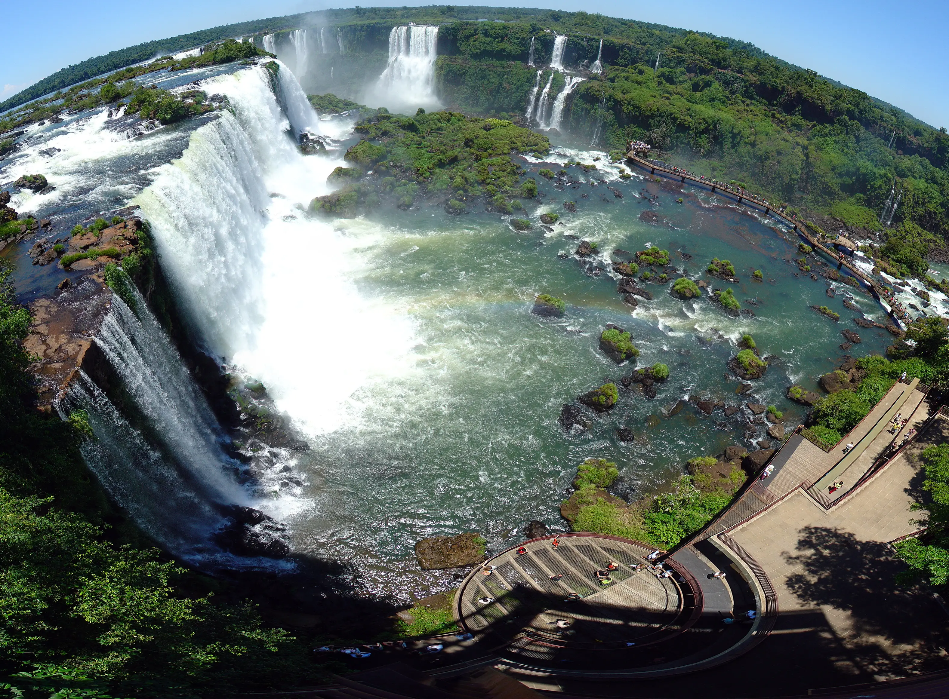 Cascades at Iguazu Falls seen from above, with a visitor walkway and subtropical forest around them